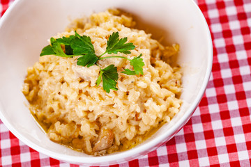 Risotto with mushrooms on white plate. Close up