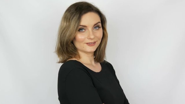 The beautiful sexy girl a bitch with flowing hair and blue eyes reproachfully looks into the camera on a white background