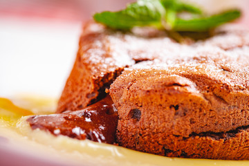 Chocolate fondant served with custard cream on white plate. Lava cake recipe. Close up