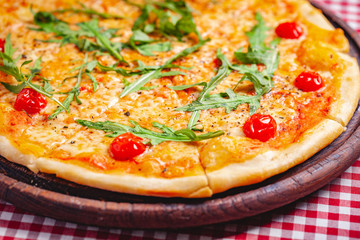 Pizza Margherita (Margarita) with fresh arugula on wooden board. Close up