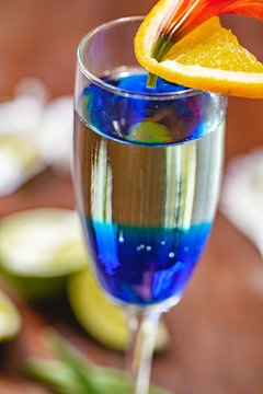 Fresh cocktail with blue curacao liqueur on wooden table. Close up