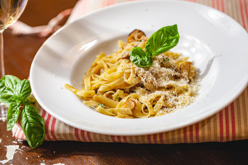 Italian pasta with mushrooms and parmesan cheese on white plate. Close up