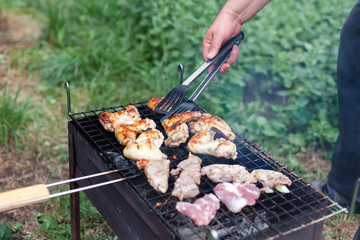 Man is cooking barbecue. Picnic with grilled meat. Bbq party in summer garden.