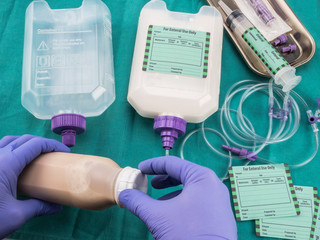 Nurse filling a bottle of enteral nutrition, Palliative Care, Conceptual Image, horizontal composition