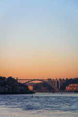 Naklejka premium view of ponte da arrabida from gaia in porto, portugal at sunset with blue and orange sky