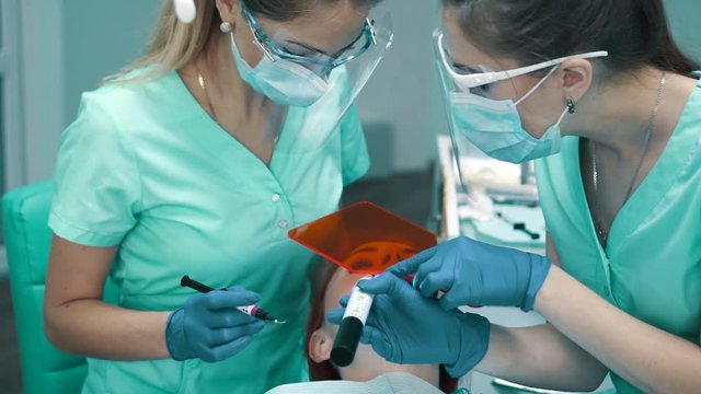 Applying insulating gel on gums and his photopolymerization lamp