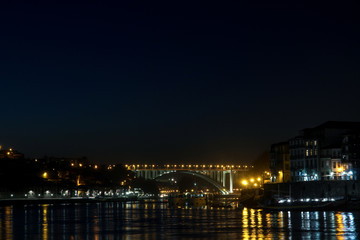 Obraz premium view of ponte da arrabida from gaia in porto, portugal at night with yellow light on bridge