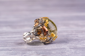 A silver ring with a natural stone in the form of green amethyst