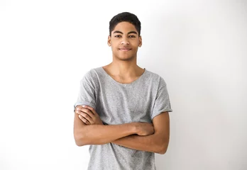 Foto op Canvas Portrait of an attractive young black man. Handsome afro american boy, teenager. Smiling guy with his hands on his chest on a white background.  © Oleksandr