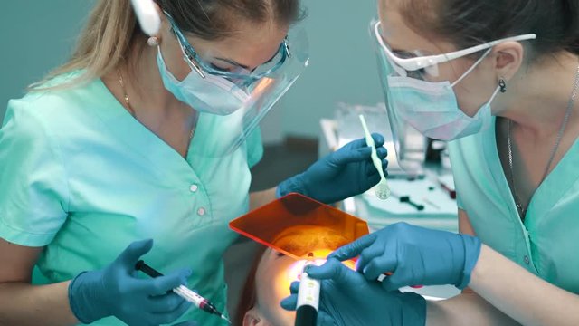 Applying insulating gel on gums and his photopolymerization lamp