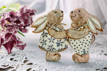 A pair of Easter gingerbread-shaped gingerbreads opposite each other next to flowers