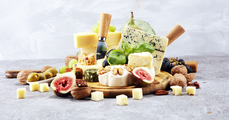 Fototapeta Cheese plate served with figs, various cheese on a platter on wood obraz