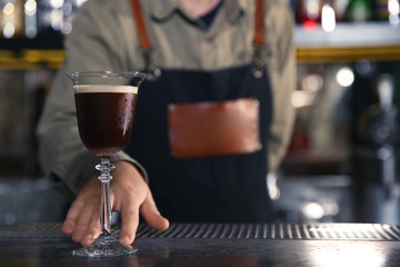 Barman serving espresso martini cocktail at counter, closeup. Space for text