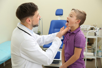 Obraz premium Male otolaryngologist examining little child in hospital