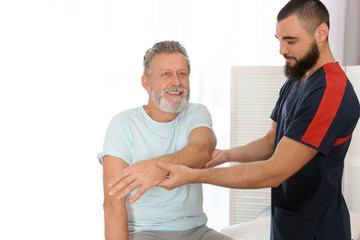 Physiotherapist working with patient in clinic. Rehabilitation therapy