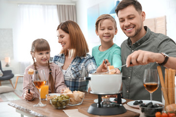 Happy family enjoying fondue dinner at home