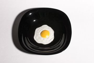 Breakfast. fried eggs in a plate on a black background.