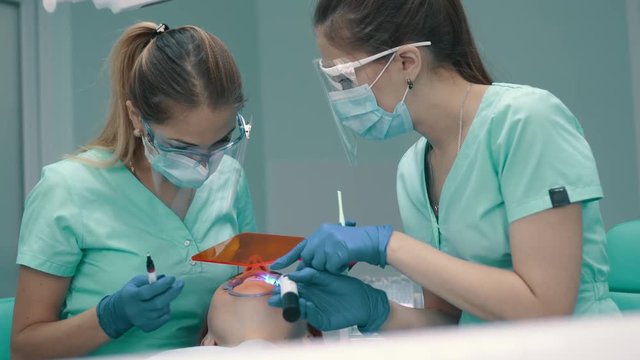 Applying insulating gel on gums and his photopolymerization lamp