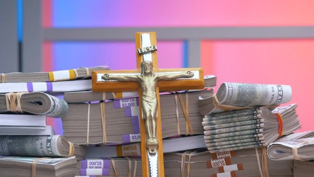 Christian crucifix with money around it on a table.