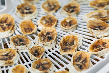 Homemade Dehydrated Bananas on grass. Dried fruit. Healthy food. Organic snack. Drying is the way to preserve the useful properties.