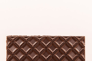 Brown chocolate bar on white background. Copy space