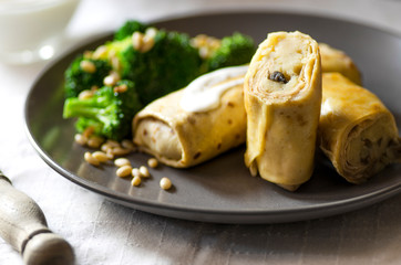 Crepes or classic russian blini with mashed potatoes, boiled broccoli and pine nuts