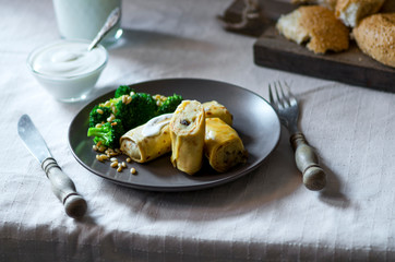 Crepes or classic russian blini with mashed potatoes, boiled broccoli and pine nuts