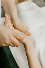 Masseur professional makes hand massage to young woman.