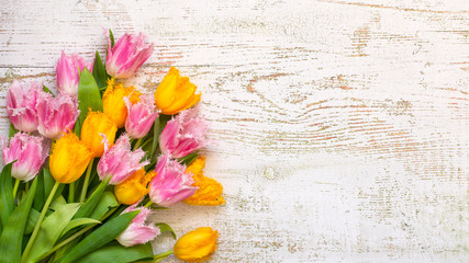 Top view of bright beautiful tulips on the white wooden background, flat lay