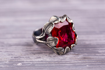 A ring in a silver frame in the form of leaves with a stone of ruby quartz
