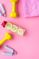 workout with bars, bottle of water and wrist builder pink background top view mockup