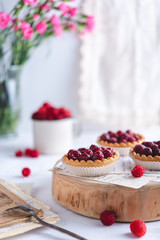 Small raspberry tarts on bright background