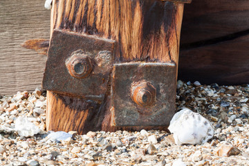 Old rusted screw in wooden seaside construction
