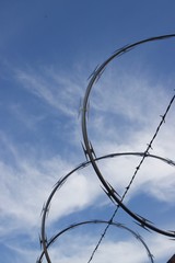 Razor wire against blue sky