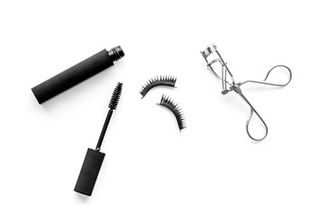 decorative cosmetic set with lash curler and mascara on white woman desk background top view