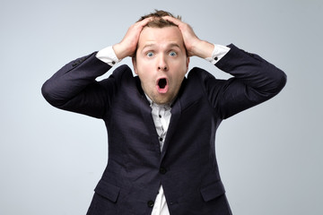 A cheerful man in a suit is surprised. Studio portrait of a surprised young manager