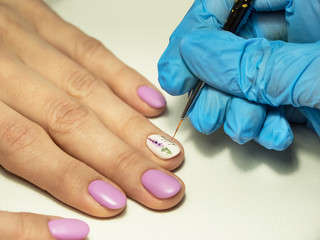 Installing rhinestones on nails. Close up.