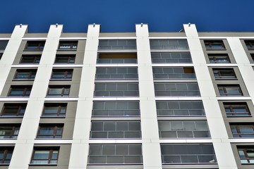 Multistory new modern apartment building. Stylish living block of flats. Modern, new executive apartments and with deep blue summer sky