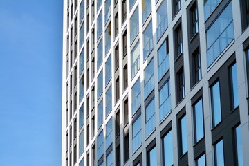 Multistory new modern apartment building. Stylish living block of flats. Modern, new executive apartments and with deep blue summer sky