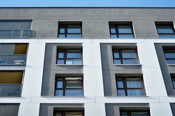 Multistory new modern apartment building. Stylish living block of flats. Modern, new executive apartments and with deep blue summer sky