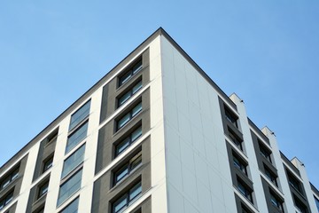 Obraz premium Multistory new modern apartment building. Stylish living block of flats. Modern, new executive apartments and with deep blue summer sky