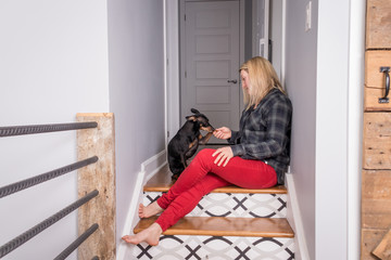 caucasian woman playing with her pinscher dog