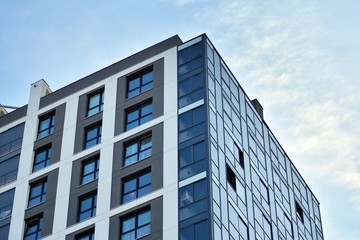 Multistory new modern apartment building. Stylish living block of flats. Modern, new executive apartments and with deep blue summer sky