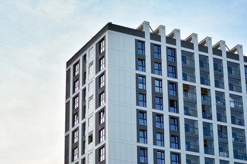 Multistory new modern apartment building. Stylish living block of flats. Modern, new executive apartments and with deep blue summer sky