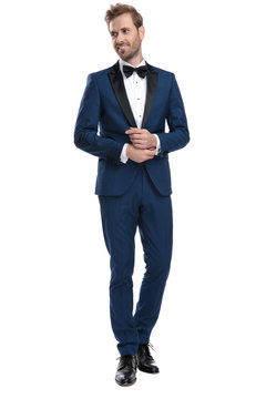elegant guy in blue tuxedo adjusting his sleeve
