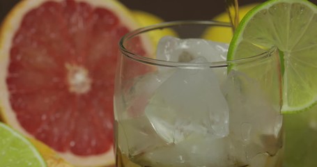 Pour whiskey, cognac, liqueur from a bottle into a glass cup. Close-up