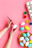 Colorful Easter eggs and paint for celebration on pink background top view mock up