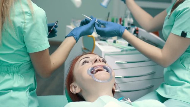 Young woman sits in chair at reception at dentist