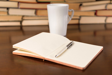 Naklejka premium open notebook and cup on the desktop