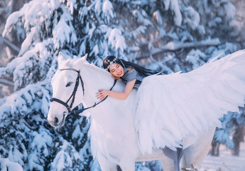 pretty dark-haired lady is lying on a white big horse, a girl in a long gray raincoat with a silver...